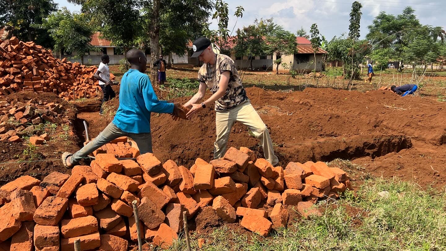 Seth laying bricks at a nursery school in Uganda