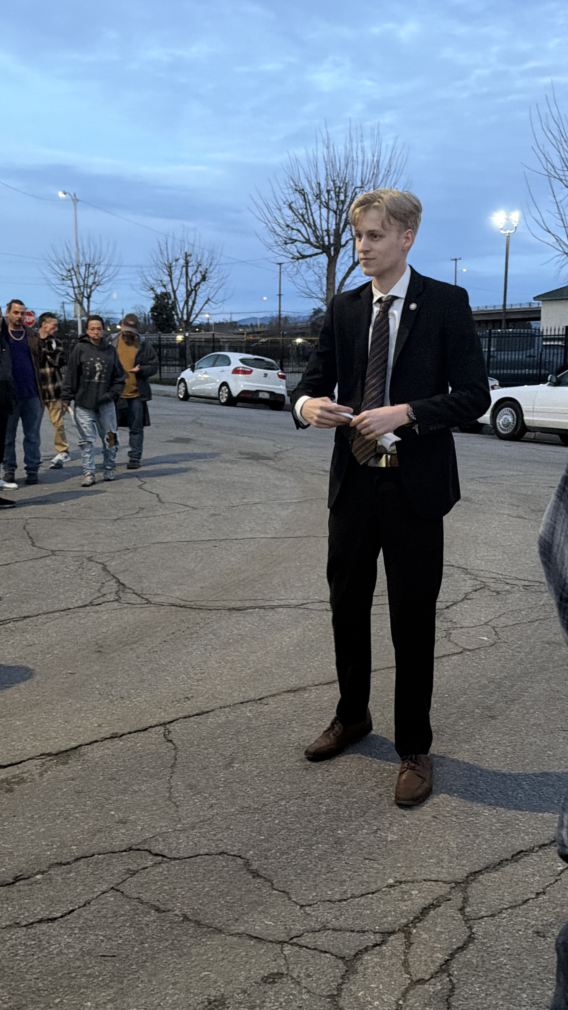 Seth speaking to a crowd of residents at dusk